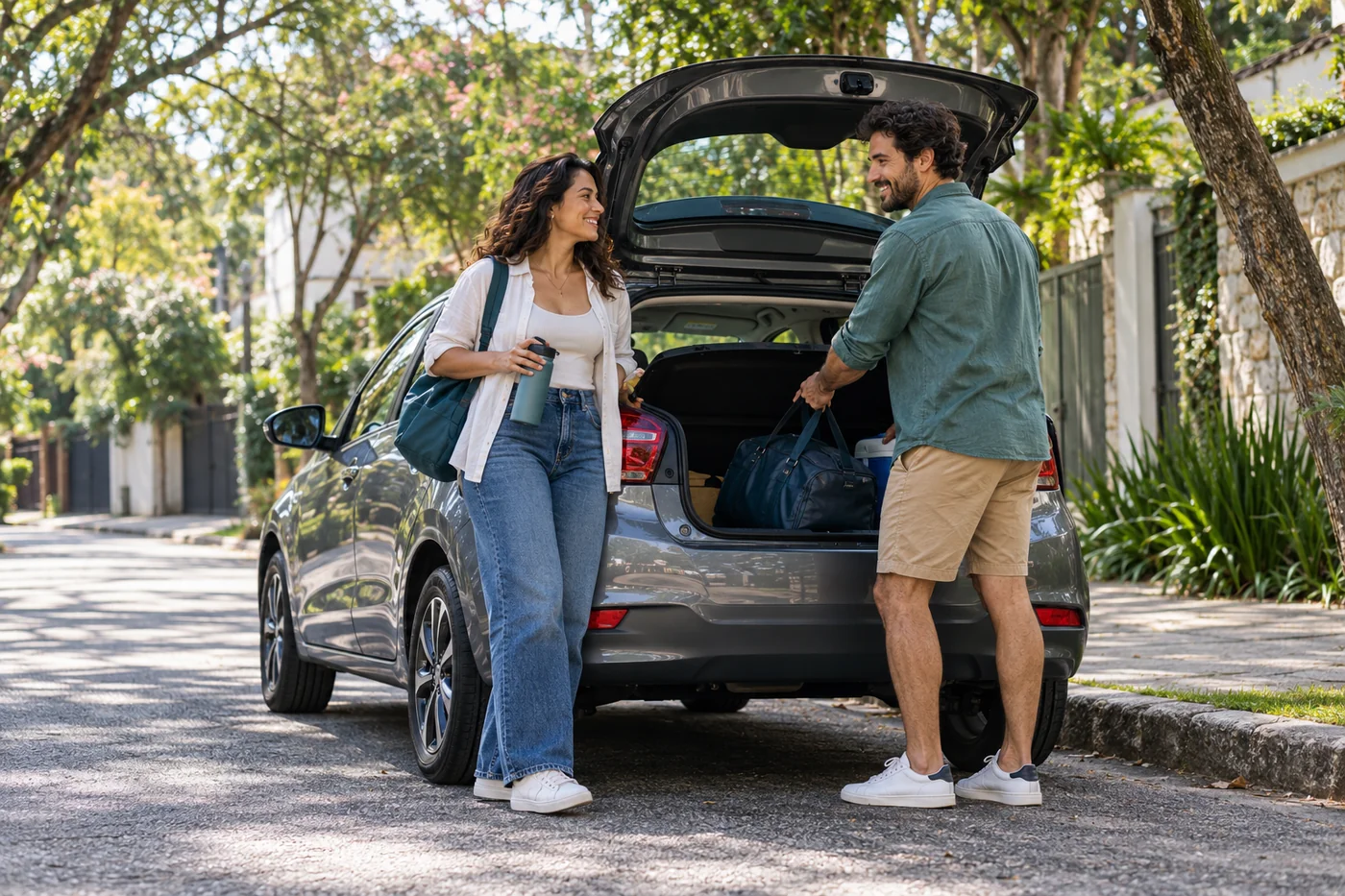 Casal preparando um passeio ao lado de seu carro em uma rua arborizada
